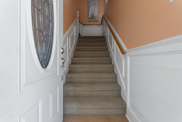 855 Dove Blvd, Bay Saint Louis, MS 39520 - staircase featuring a decorative wall, wainscoting, and tile patterned flooring