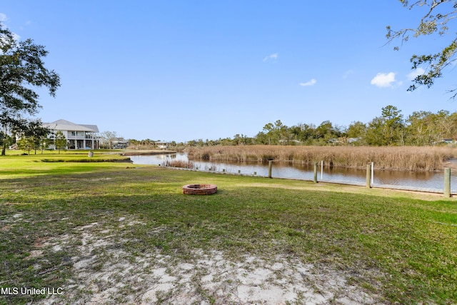 view of yard featuring a water view and an outdoor fire pit