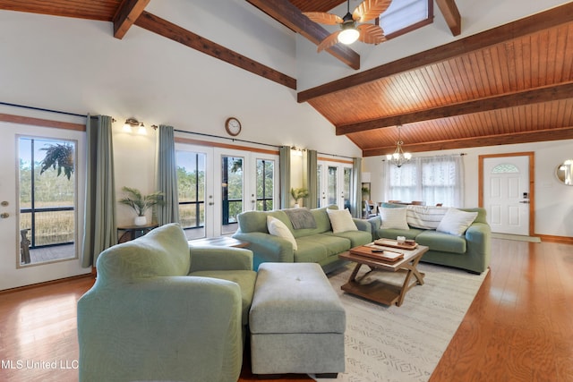 living room with ceiling fan with notable chandelier, beam ceiling, light wood-type flooring, and high vaulted ceiling