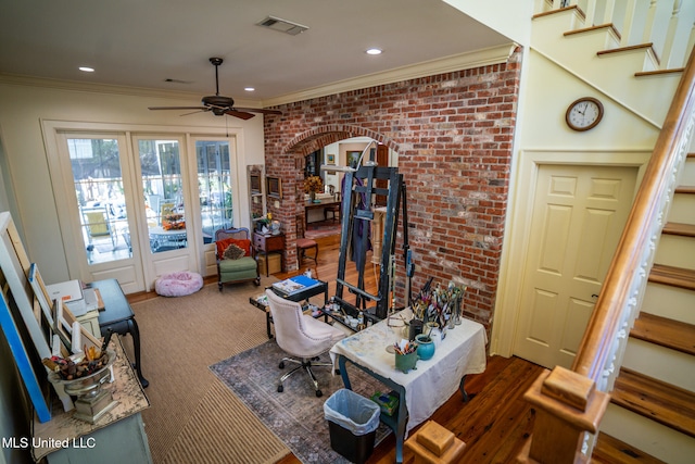 interior space featuring dark wood-type flooring, french doors, ceiling fan, ornamental molding, and brick wall