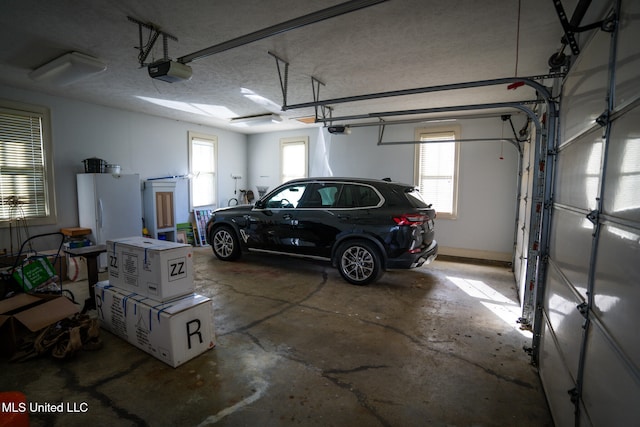 garage with white refrigerator and a garage door opener