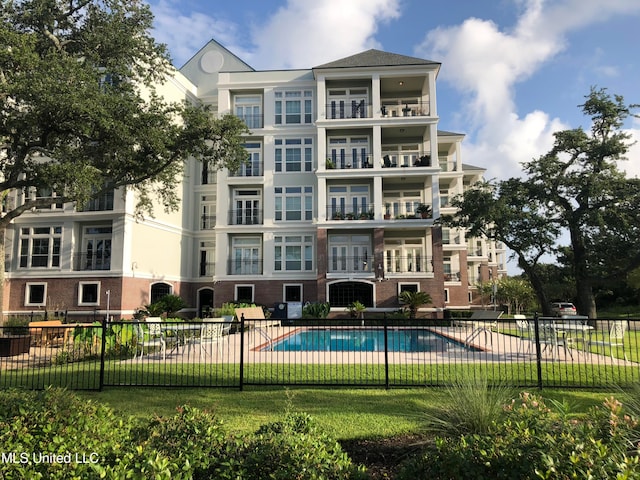 view of pool with a lawn