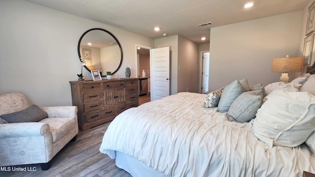 bedroom with recessed lighting, visible vents, and wood finished floors