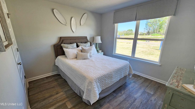 bedroom featuring dark wood-type flooring, multiple windows, and baseboards