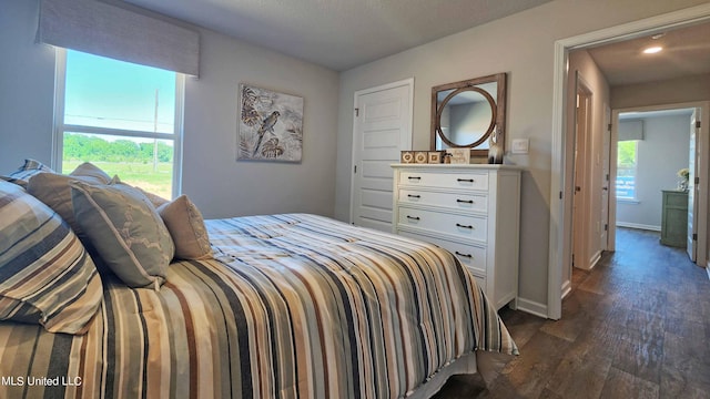 bedroom featuring baseboards and dark wood-style flooring