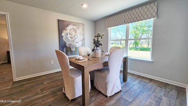 dining area featuring dark wood finished floors, baseboards, and a textured ceiling