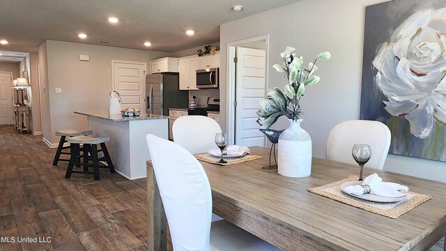 dining room featuring dark wood finished floors, recessed lighting, and baseboards