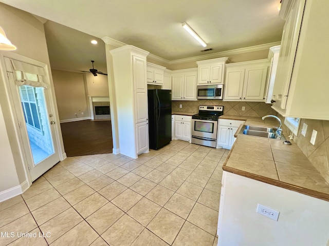 kitchen featuring light tile patterned floors, sink, white cabinets, and stainless steel appliances