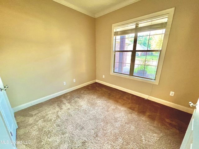 empty room featuring dark carpet and ornamental molding