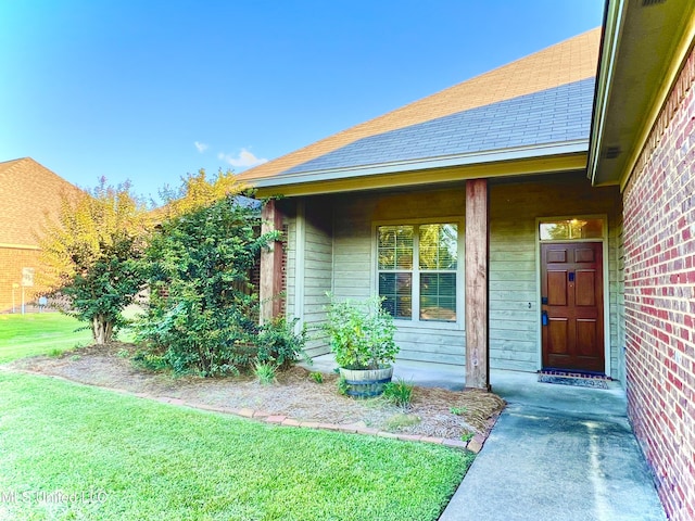 doorway to property with a lawn