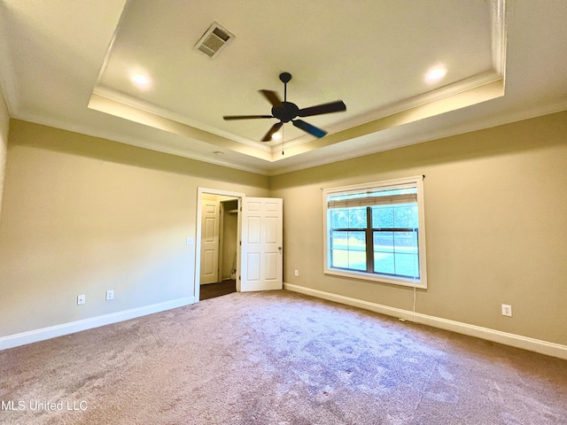 unfurnished bedroom with ceiling fan, ornamental molding, and a raised ceiling