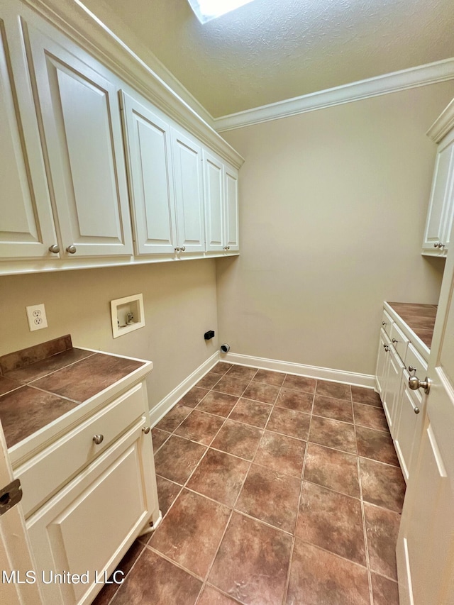 laundry room featuring cabinets, crown molding, hookup for a washing machine, and dark tile patterned floors