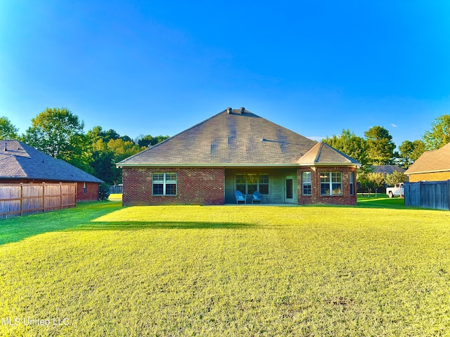 back of house with a lawn