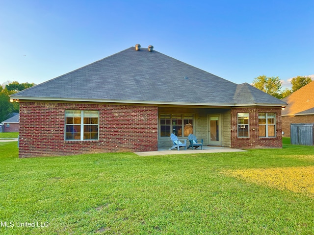 back of house with a patio area and a lawn