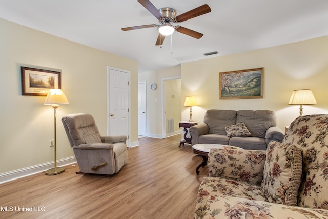 living room with light hardwood / wood-style flooring and ceiling fan