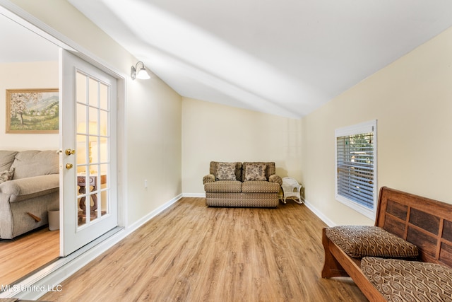 living area featuring light hardwood / wood-style flooring and vaulted ceiling