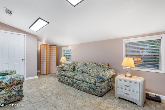 tiled living room featuring plenty of natural light and lofted ceiling