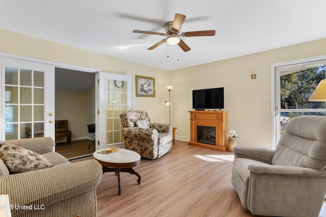 living room featuring ceiling fan, french doors, and light hardwood / wood-style floors