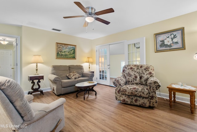 living room with ceiling fan, light hardwood / wood-style flooring, and french doors