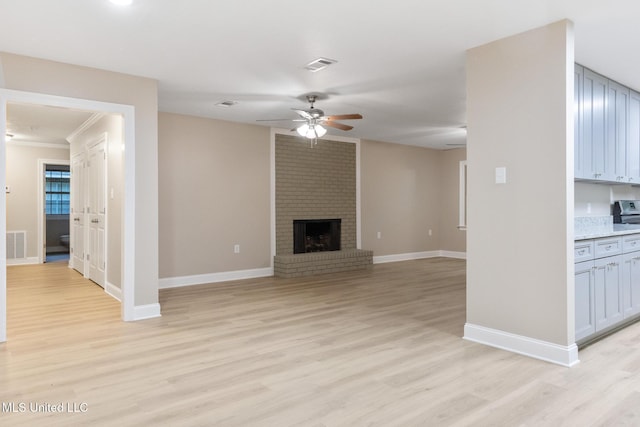 1304 Estelle St, Hattiesburg, MS 39402 - unfurnished living room featuring ceiling fan, light wood finished floors, a brick fireplace, and crown molding