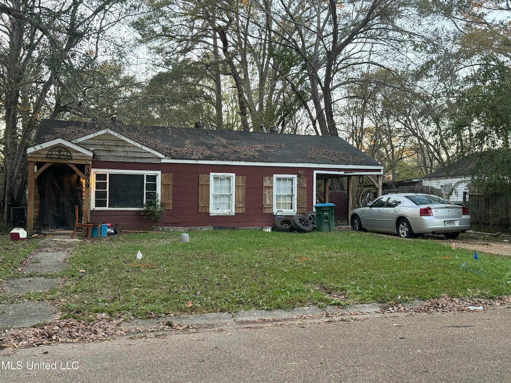 view of front facade featuring a front lawn and a carport