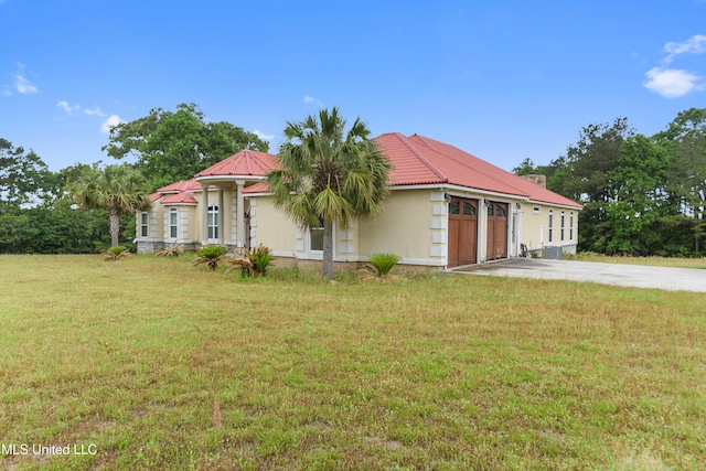 view of front of property featuring concrete driveway, a tiled roof, a front yard, stucco siding, and a garage