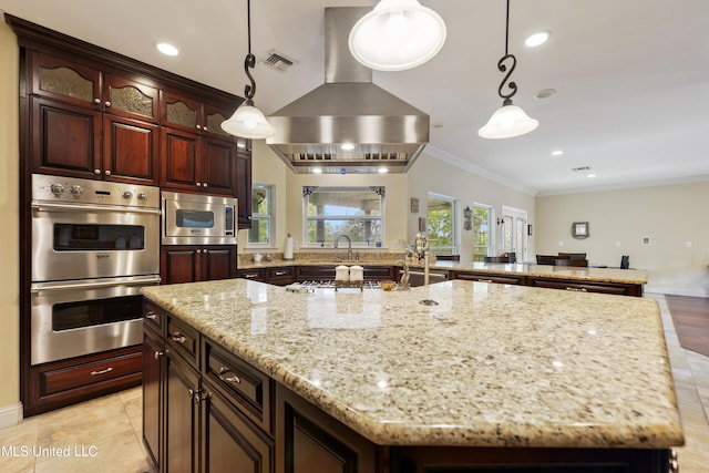 kitchen with light stone counters, appliances with stainless steel finishes, a kitchen island, wall chimney range hood, and crown molding