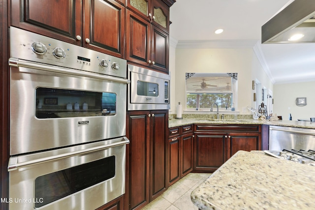 kitchen with a sink, light tile patterned floors, crown molding, light stone counters, and appliances with stainless steel finishes