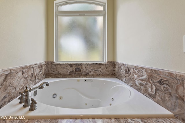 full bath featuring a jetted tub and a healthy amount of sunlight