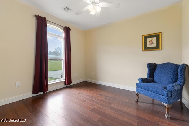 living area with a ceiling fan, visible vents, wood finished floors, and baseboards