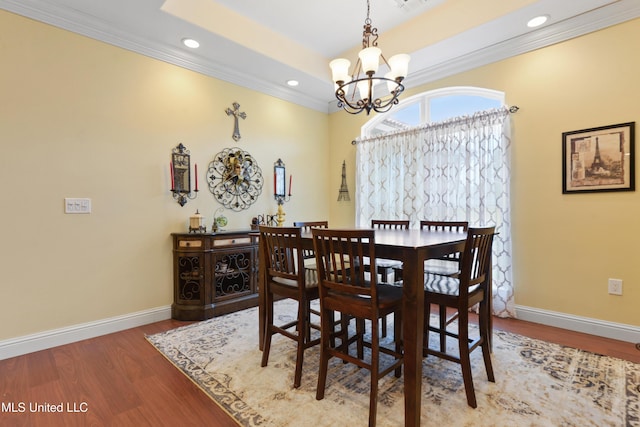 dining space featuring ornamental molding, wood finished floors, a chandelier, and baseboards