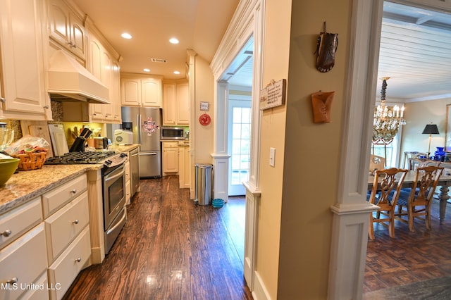 204 Arlington Ave, Natchez, MS 39120 - kitchen with appliances with stainless steel finishes, under cabinet range hood, dark wood-style flooring, light stone countertops, and recessed lighting