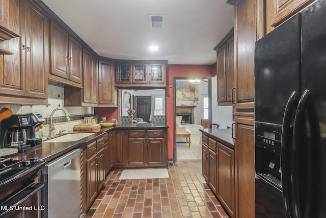 2213 N St, Gulfport, MS 39507 - kitchen with black appliances, a sink, brick flooring, dark countertops, and recessed lighting