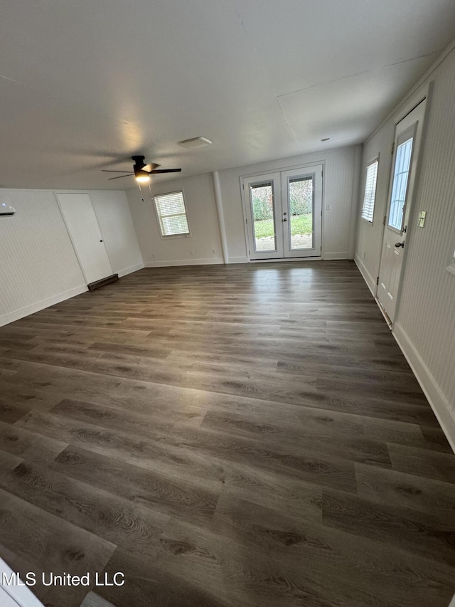 empty room featuring dark wood-style flooring, a wealth of natural light, and baseboards