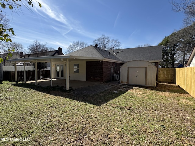 rear view of property featuring brick siding, a patio area, a shed, a fenced backyard, and an outdoor structure