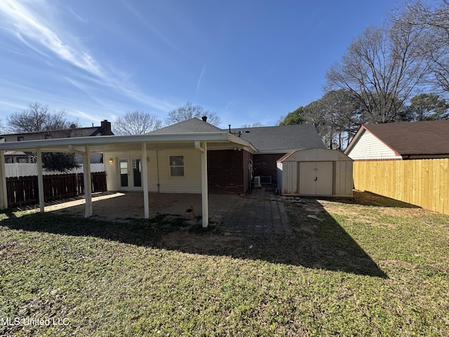 rear view of property with an outbuilding, a patio, a fenced backyard, a lawn, and a shed