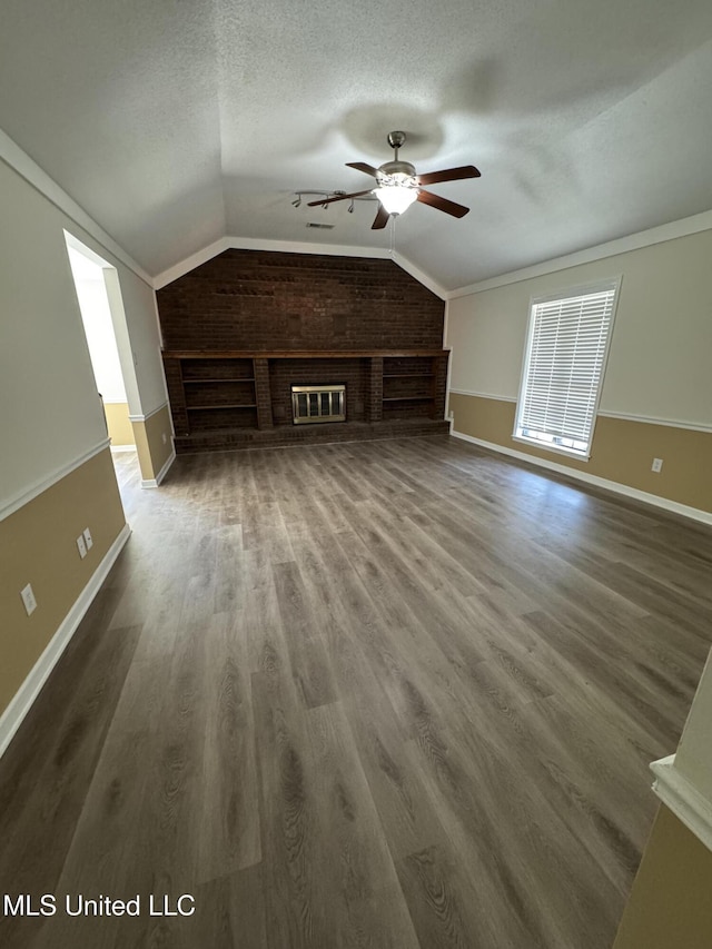 unfurnished living room featuring ceiling fan, vaulted ceiling, a textured ceiling, and wood finished floors