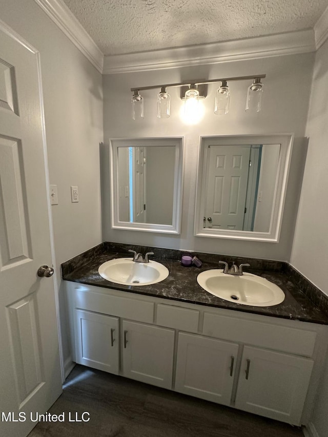 bathroom featuring vanity, ornamental molding, and a textured ceiling