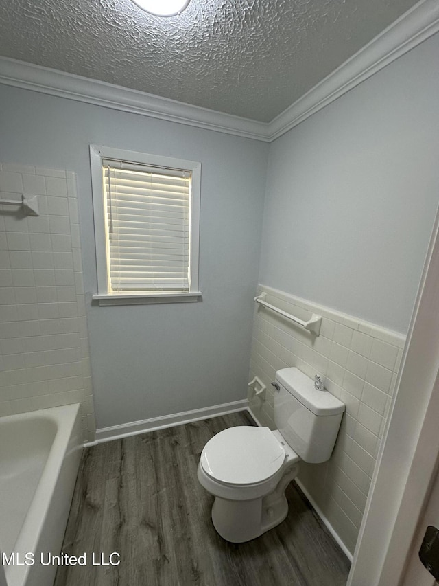 bathroom with hardwood / wood-style flooring, toilet, ornamental molding, and a textured ceiling