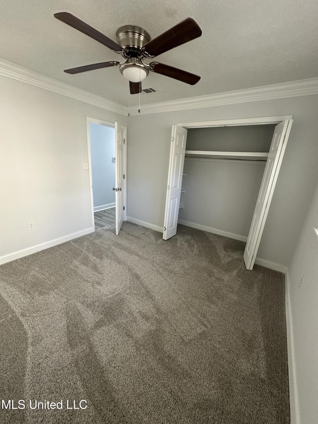 unfurnished bedroom featuring ceiling fan, carpet floors, crown molding, and a closet