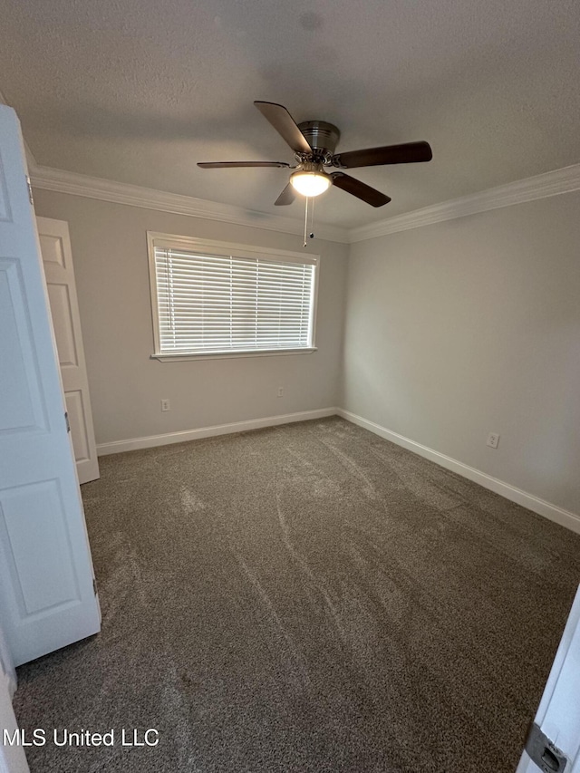 empty room featuring ceiling fan, dark carpet, a textured ceiling, and ornamental molding