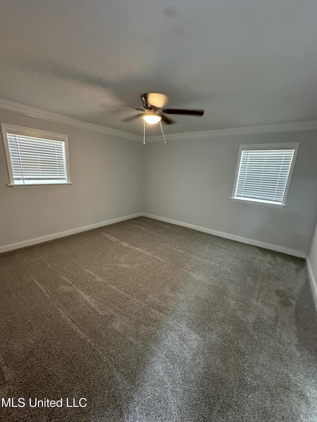 empty room with dark carpet, ceiling fan, and crown molding