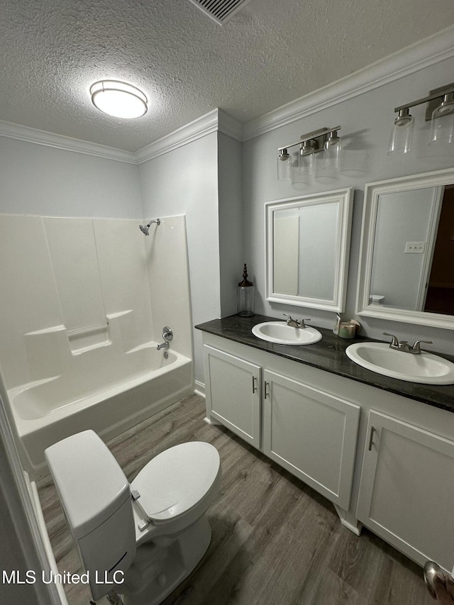 full bathroom featuring vanity, washtub / shower combination, toilet, a textured ceiling, and wood-type flooring