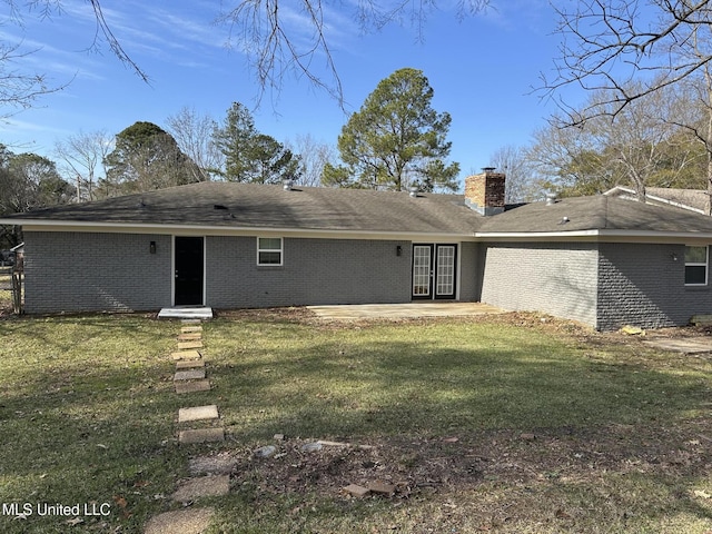 back of house featuring a lawn and a patio