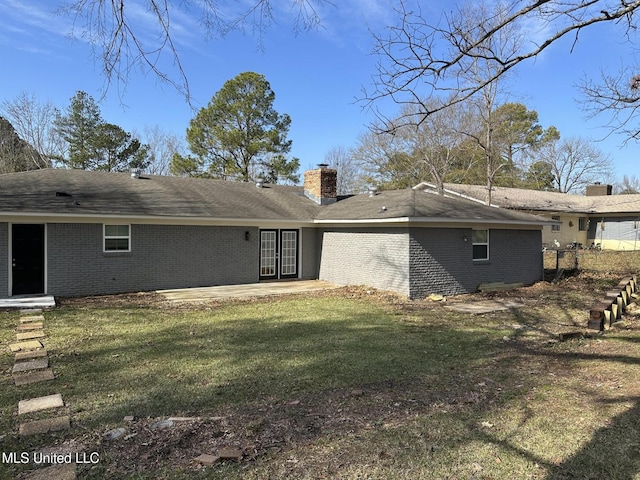 rear view of property with a lawn and a patio