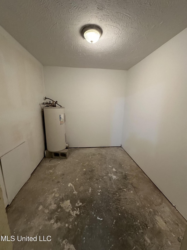 basement with a textured ceiling and electric water heater