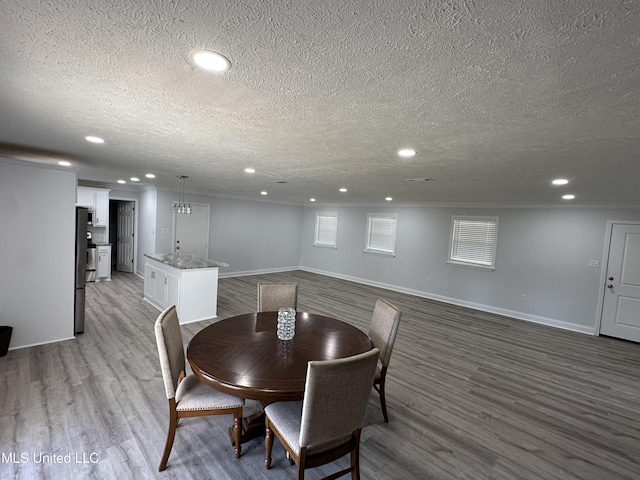 dining area featuring a textured ceiling and light hardwood / wood-style flooring