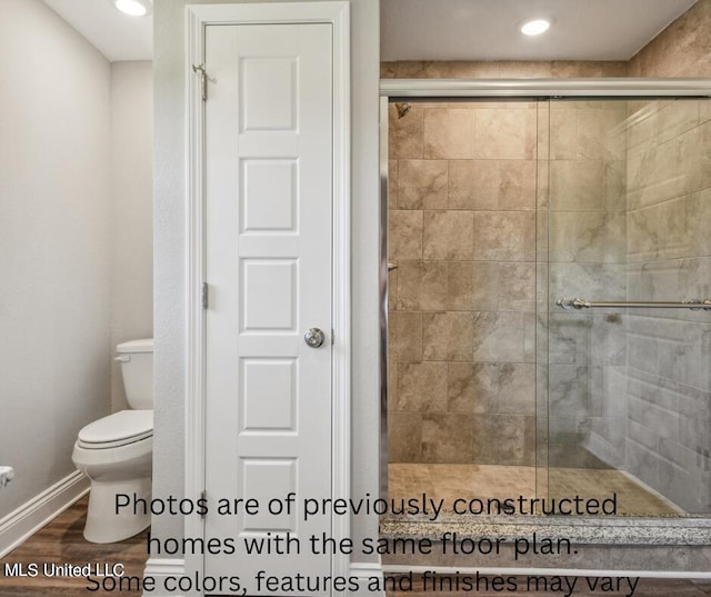 bathroom featuring toilet, walk in shower, and hardwood / wood-style floors