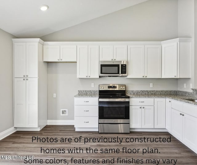 kitchen with white cabinetry, stainless steel appliances, light stone countertops, and vaulted ceiling