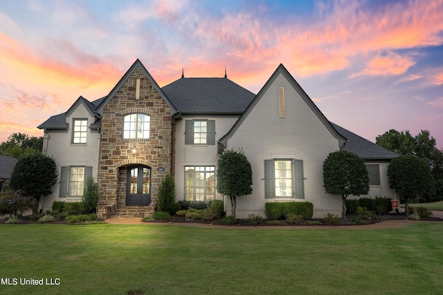 french country inspired facade with french doors and a lawn